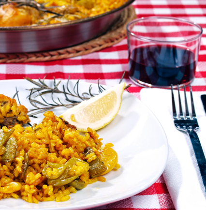 image of a paella and a glass of wine